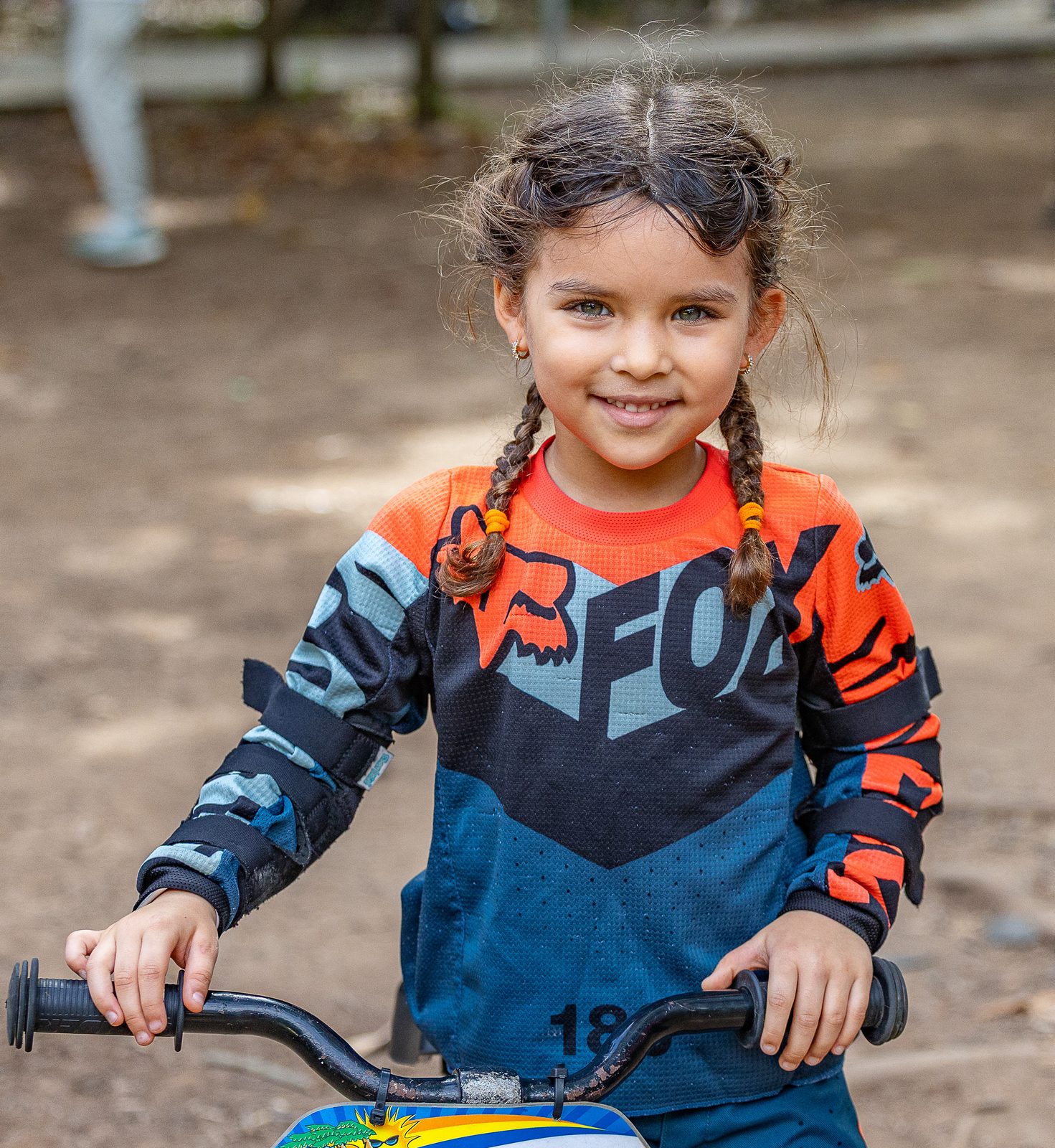 Niña sonriendo sobre su bicicleta antes de la clase